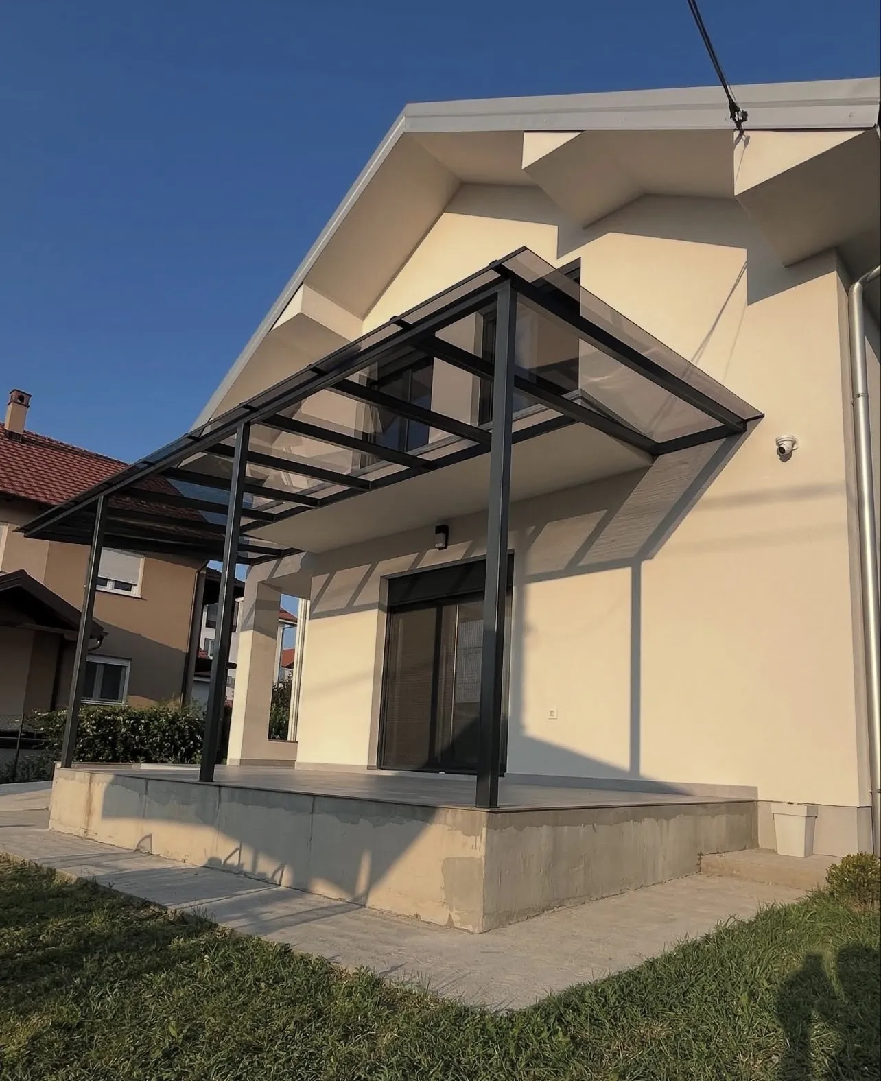 Staklena nadstrešnica nad ulazom — bela kuća