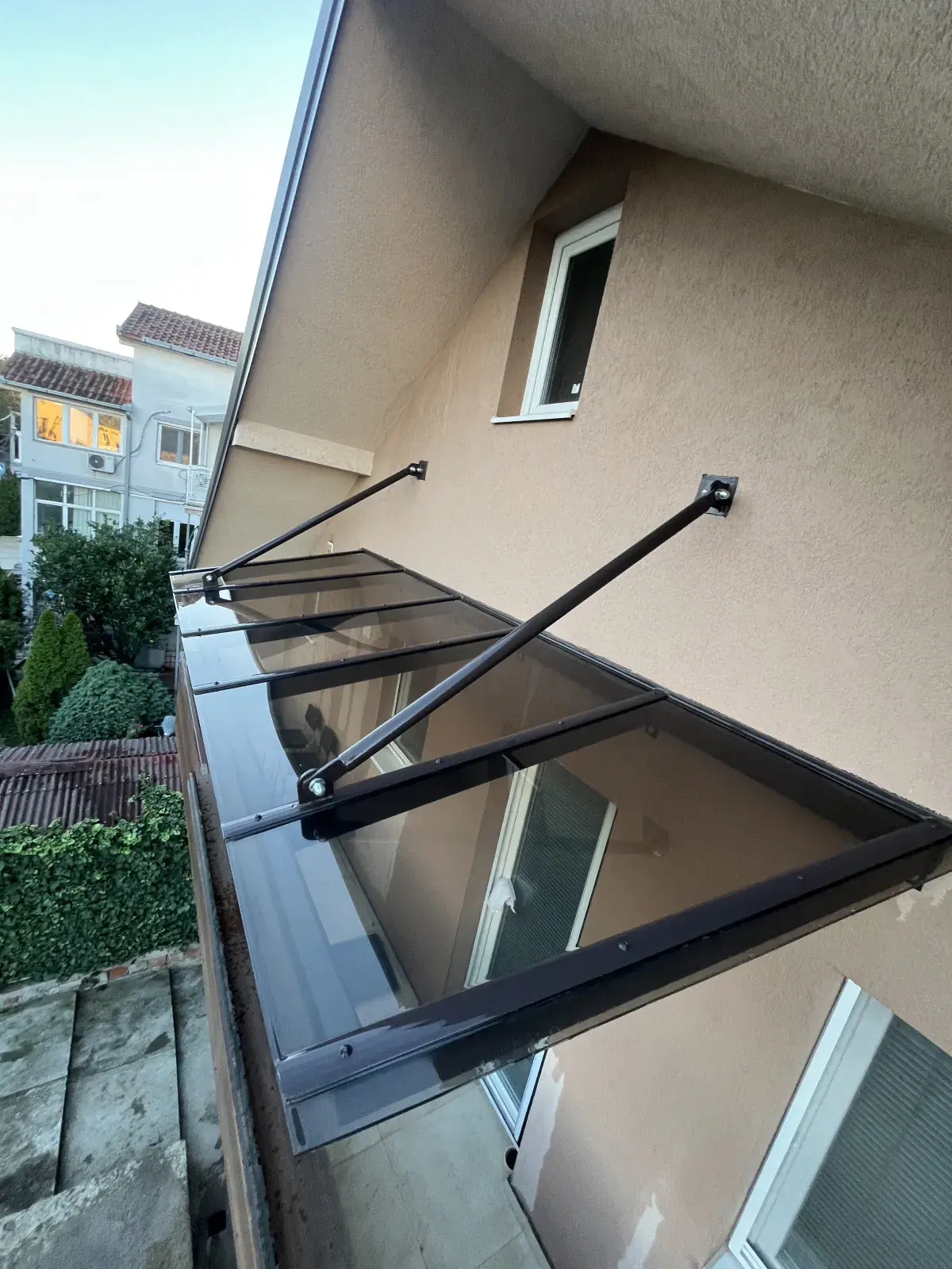 Braon staklena nadstrešnica sa zateznim šipkama